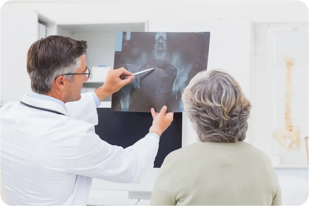 Orthopäde erklärt Patientin Osteoporose